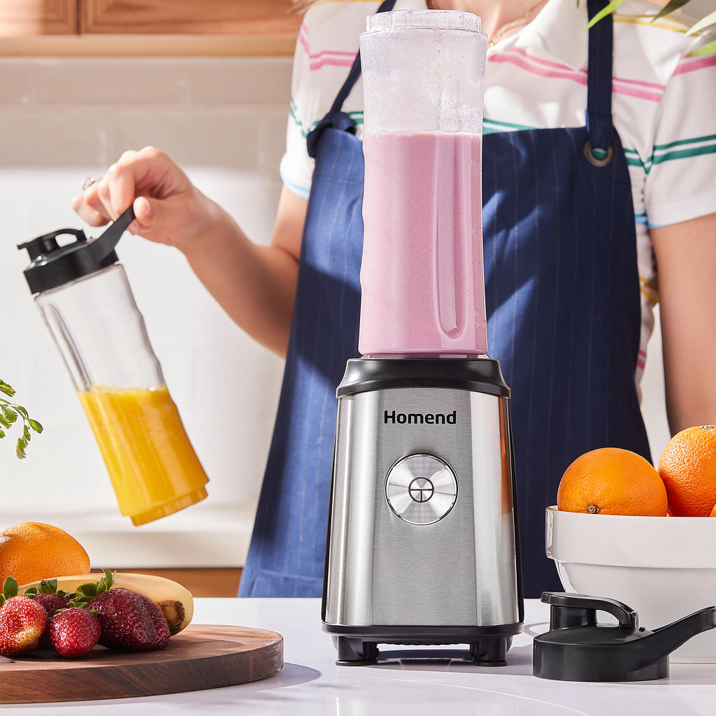 A person making smoothies with a blender, surrounded by fresh fruit on a kitchen counter. Bottles' cover has a handle to hold the smoothie in ergonomic way as well as spill-proof feature.