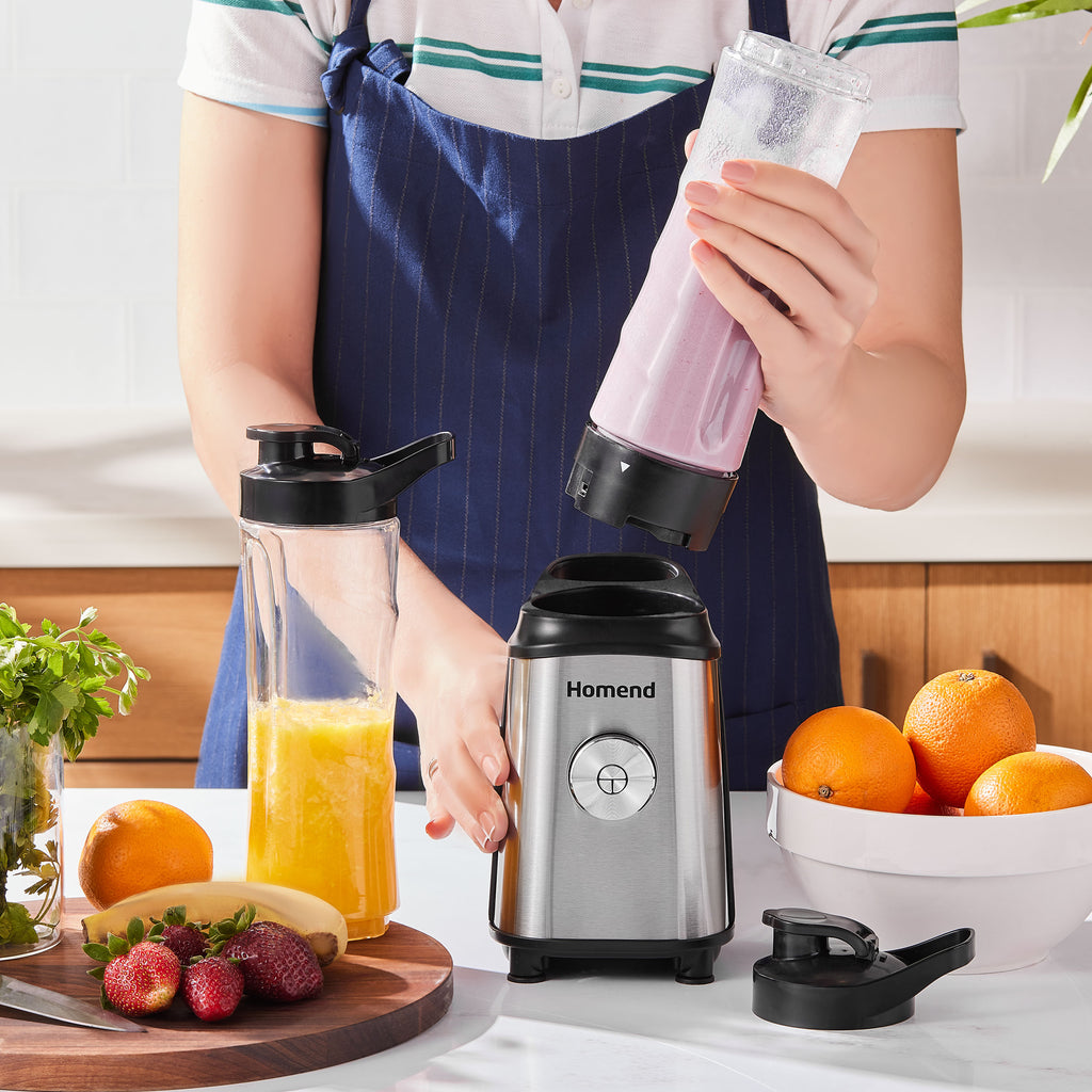Person using a blender to make a smoothie with fruits around on a kitchen counter.
